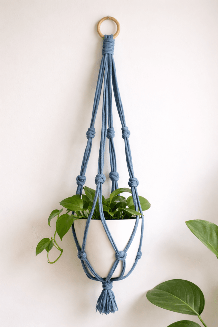 Easy DIY denim plant hanger with simple knot design, made from old jeans and holding a white pot with trailing plant