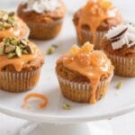 Final dish presentation: Bakery-style vegan carrot muffins fully cooled, each with a light orange gl