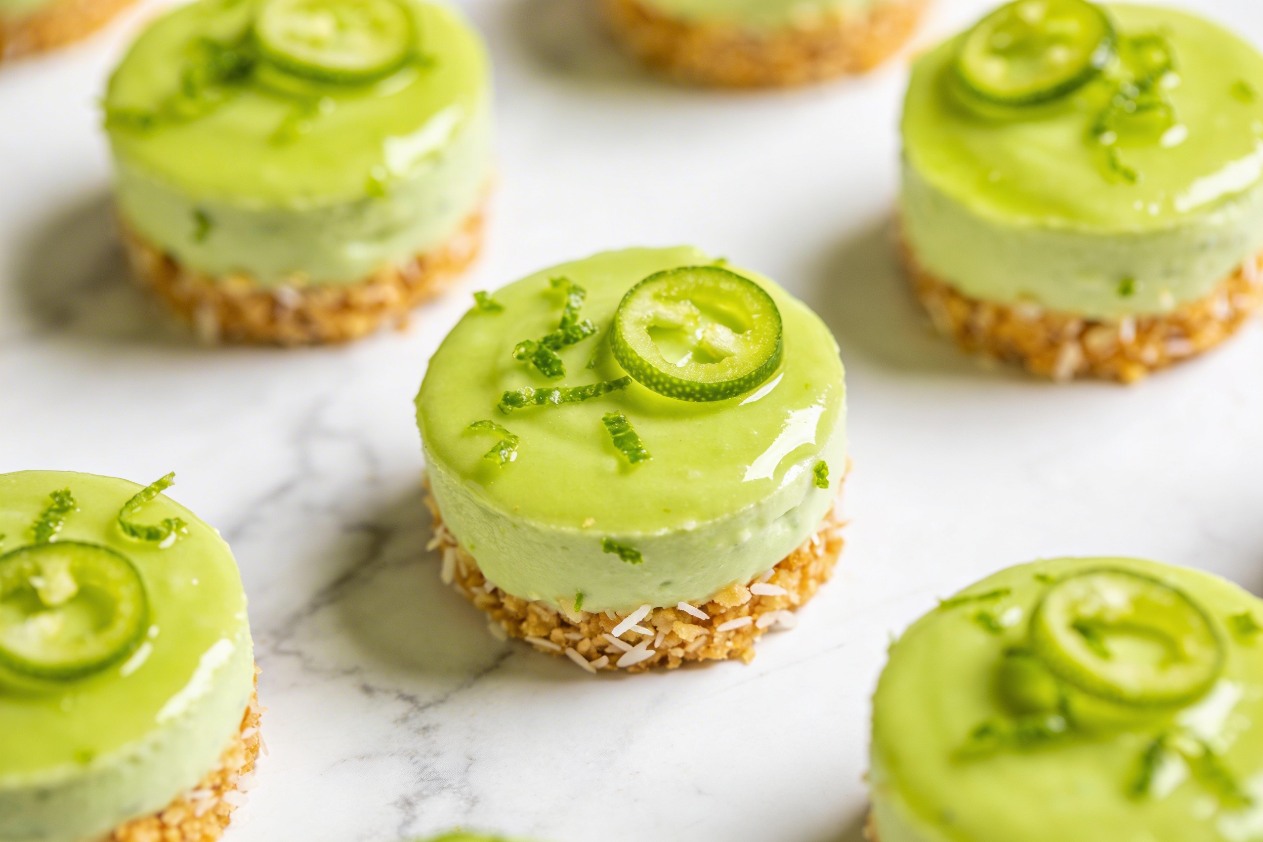 Assorted mini vegan key lime cheesecake bites with lime zest.