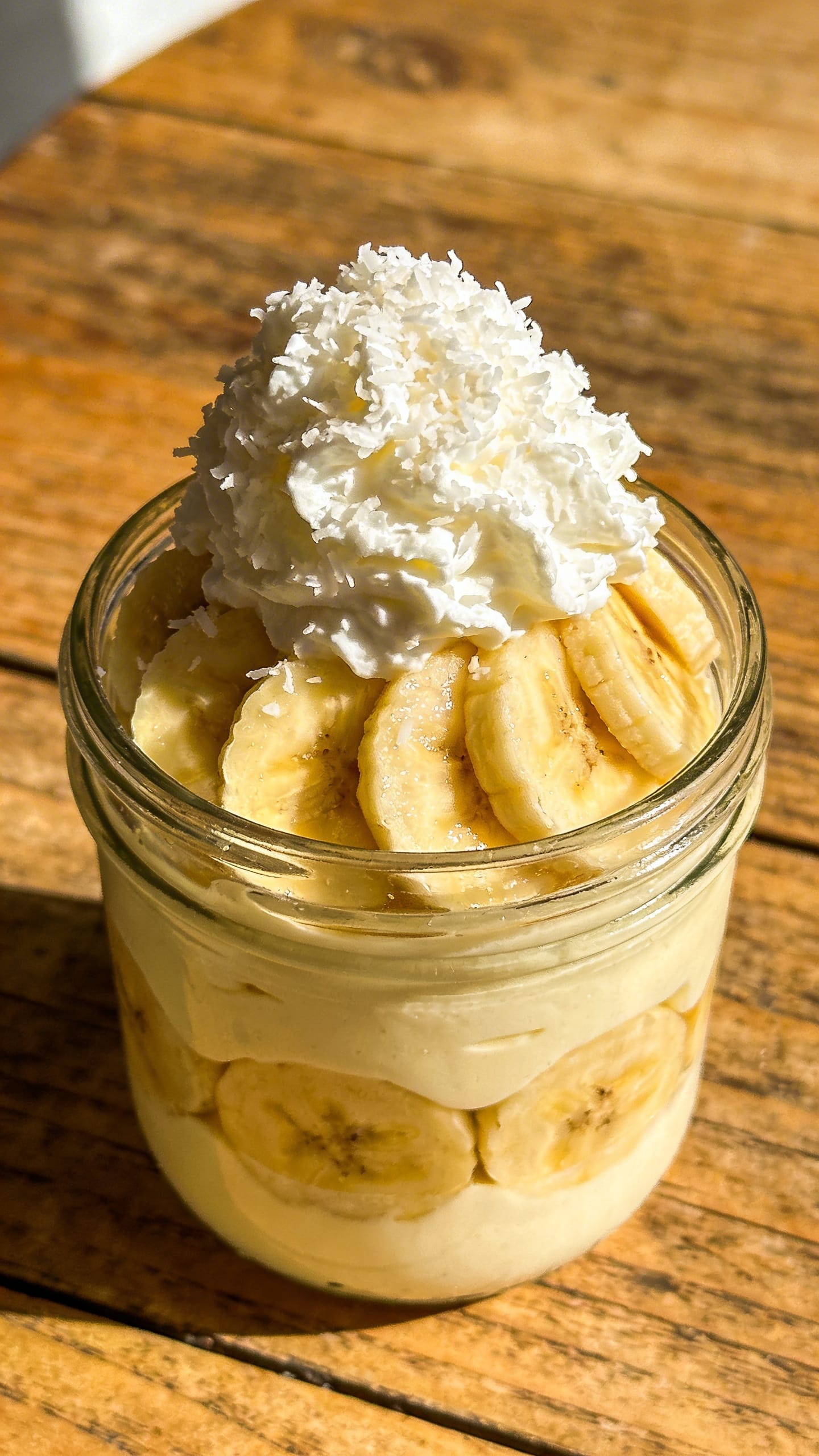 Glass dessert pot with banana cream layers overhead