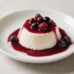Vegan Coconut Panna Cotta: Silky, plant-based dessert crowned with fresh berries & vibrant coulis, ideal for guilt-free treats. Save this idea so you can come back to it later.