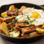 Crispy Breakfast Skillet: Rustic cast iron pan with crispy Yukon Gold potatoes, sizzling sausage, and a runny egg&mdash;weekend brunch bliss. Save this idea so you can come back to it later.