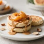 Vegan Pancake Bliss: Fluffy, golden pancakes with caramel & juicy peaches, scattered almonds—ideal for breakfast lovers. Save this idea so you can come back to it later.
