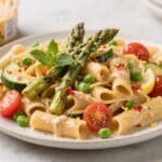 Spring Hummus Pasta: Vibrant, creamy pasta piled with asparagus, peas, and mint. Healthy & flavor-packed&mdash;ideal for quick dinners. Save this idea so you can come back to it later.