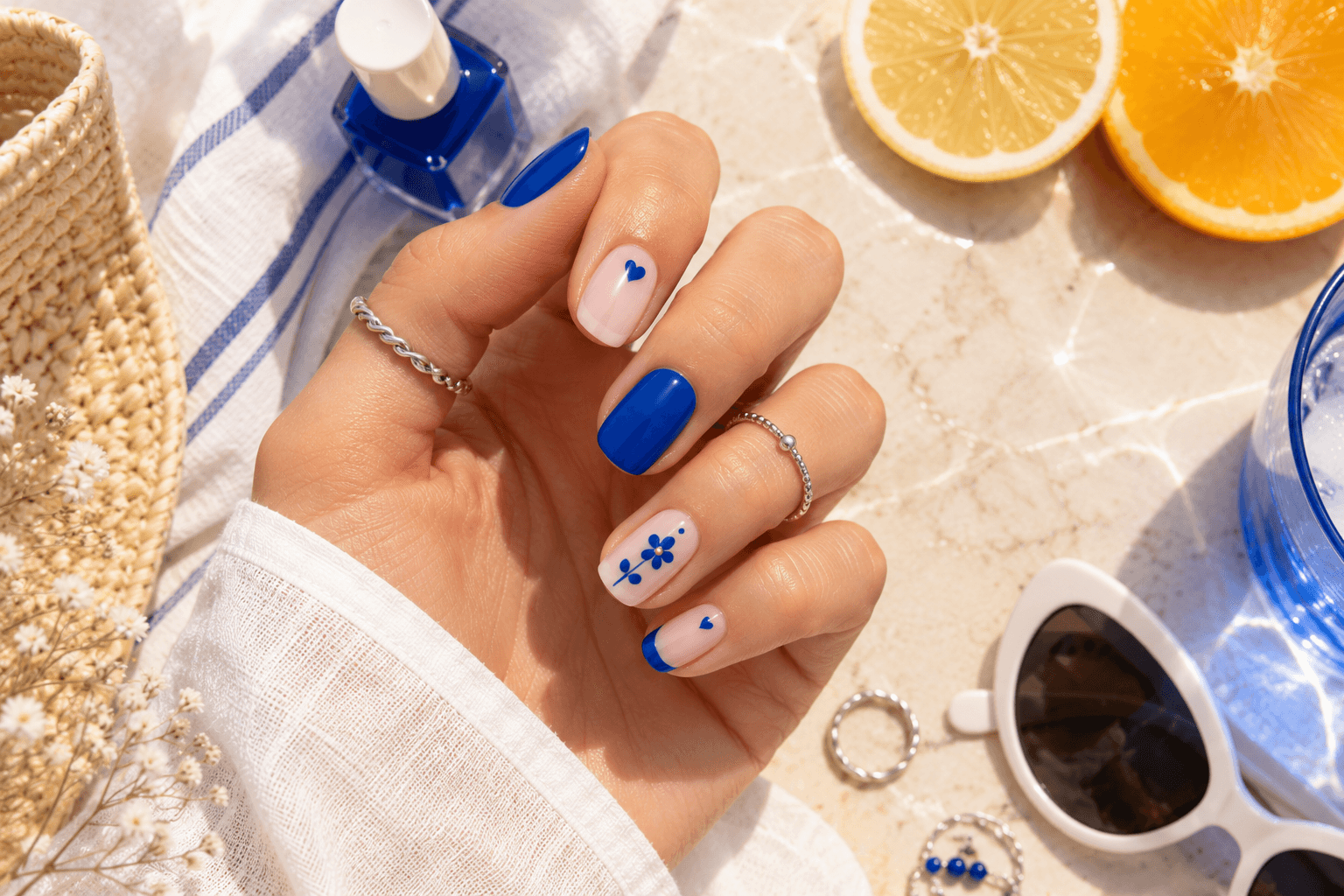 Bold Summer Nails: Chic manicure with cobalt blue, hearts, and floral details. Fresh, vibrant look—perfect for vacation vibes. Save this idea so you can come back to it later.