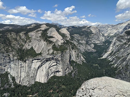 Granite cliffs and forested Yosemite Valley and Tenaya Canyon seen from Glacier Point.